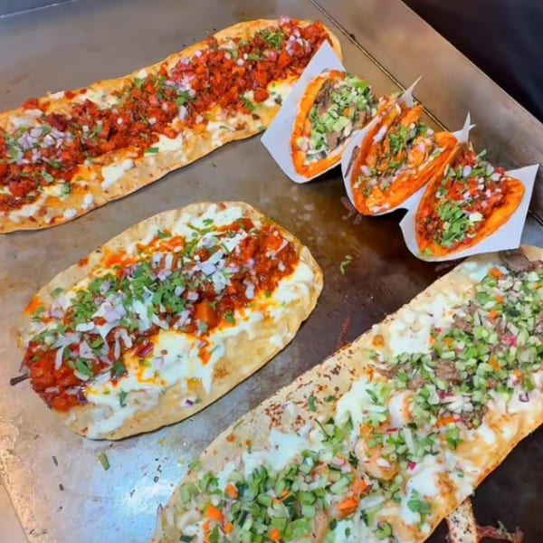 A close-up of Machetes Gourmet's Mexican food, including long flatbreads with toppings and tacos.
