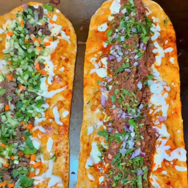 Two long Machetes Gourmet Mexican machetes, one with diced vegetables, the other with meat, onions, and cilantro.
