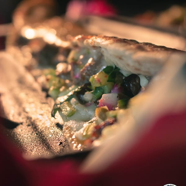 Close-up of a Machetes Gourmet quesadilla, filled with melted cheese, diced vegetables, and meat.